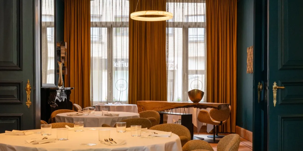 Gerenoveerde eetzaal van Hostellerie Lesco in Wetteren met ronde hanglamp en hoge ramen
